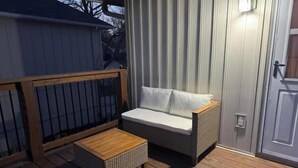 Een terras met een houten tafel en een bank.