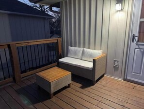 Eine Terrasse mit einem Holztisch und einer Couch.
