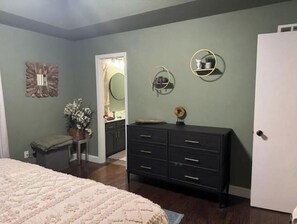 Ein Schlafzimmer mit einem Bett, einem Schminktisch und einem Spiegel.