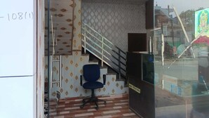 A reception area with a staircase, a reception desk, and a chair.