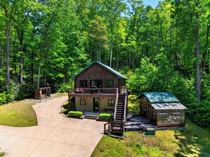 A cabin with a balcony, a covered porch, and a staircase leading to the main entrance. - Cozy Cabin + Bunks | Porch + Firepit | Waterfalls + Brevard | The Hearthwood (Lake Toxaway)