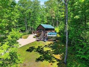 A cabin with a deck, a covered outdoor seating area, and a staircase leading to the entrance. - Cozy Cabin + Bunks | Porch + Firepit | Waterfalls + Brevard | The Hearthwood (Lake Toxaway)