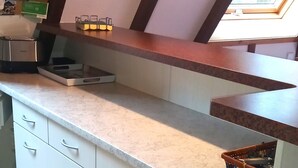 Una cocina con armarios blancos, una encimera y un ventanal con vistas.