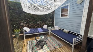 A deck with two beds, a table, and a hanging white lace canopy. - Magnificent mobile home (Messanges)