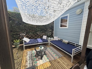 A deck with two beds, a table, and a hanging white lace canopy. - Magnificent mobile home (Messanges)