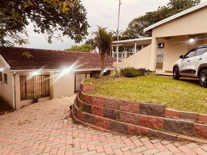 Un camino de entrada residencial que conduce a una casa, con un coche estacionado allí.