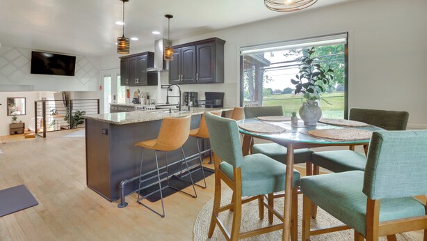 A modern kitchen with a central island, dining area with chairs, and a large window with a view. - GREEN LANTERN: Game Room, Furnished Deck, Modern (Lexington)