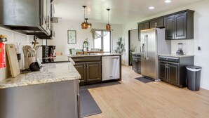 A modern kitchen with stainless steel appliances, dark cabinetry, and a granite countertop. - GREEN LANTERN: Game Room, Furnished Deck, Modern (Lexington)