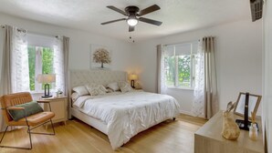 A bedroom with a bed, a chair, a nightstand, a ceiling fan, and a window. - GREEN LANTERN: Game Room, Furnished Deck, Modern (Lexington)