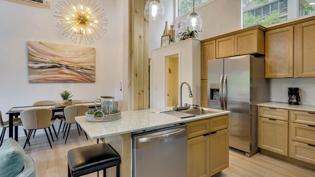 A modern kitchen with a central island, stainless steel appliances, wooden cabinets, and pendant lighting. - Margaritaville Access! Luxe Ozark Oasis w/ Hot Tub (Osage Beach)