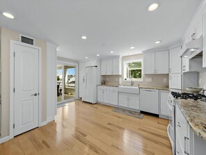 A modern kitchen with white cabinets, a granite countertop, and a built-in stove. - Immaculate 4 bed/2.5 bath home in the heart of Ship Bottom (Ship Bottom)