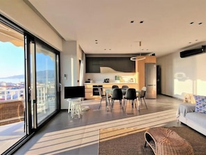 Eine moderne Wohnung mit Balkon, einer Küche und einem Wohnbereich.