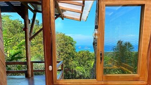 A wooden room with a large window, two chairs, and a table.