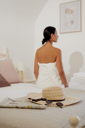 A room with a bed, a hat, sunglasses, and a magazine on the bed. - Masseria Dimora Zezzella Belvedere Lodging (Puglia)