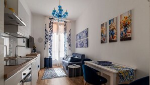 A modern kitchen with a dining area, a sofa, and artwork on the walls. - A comfortable and charming 40 square meters apartment, perfect for three people, located on the second floor of a period building with an elevator (NOT accessible to disabled guests).The property is located near Rome Termini Station and the Castro Pretor (Rome)