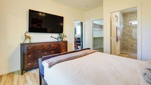 A bedroom with a bed, a dresser, a TV, and a shower area. - Private Acreage, Pet-Friendly Yard! Gilbert Haven (Gilbert)