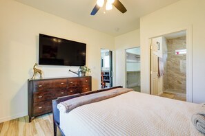 A bedroom with a bed, a dresser, a TV, and a shower area. - Private Acreage, Pet-Friendly Yard! Gilbert Haven (Gilbert)