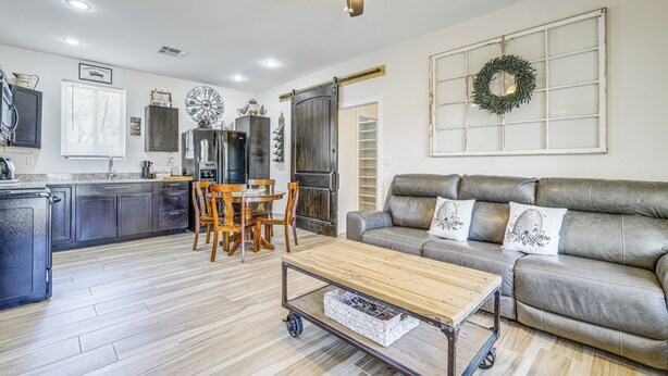 A modern kitchen with a dining area, a living room with a sofa, and a ceiling fan. - Private Acreage, Pet-Friendly Yard! Gilbert Haven (Gilbert)