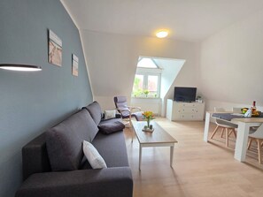 Un moderno apartamento estilo loft con sala de estar, comedor y pequeña cocina.