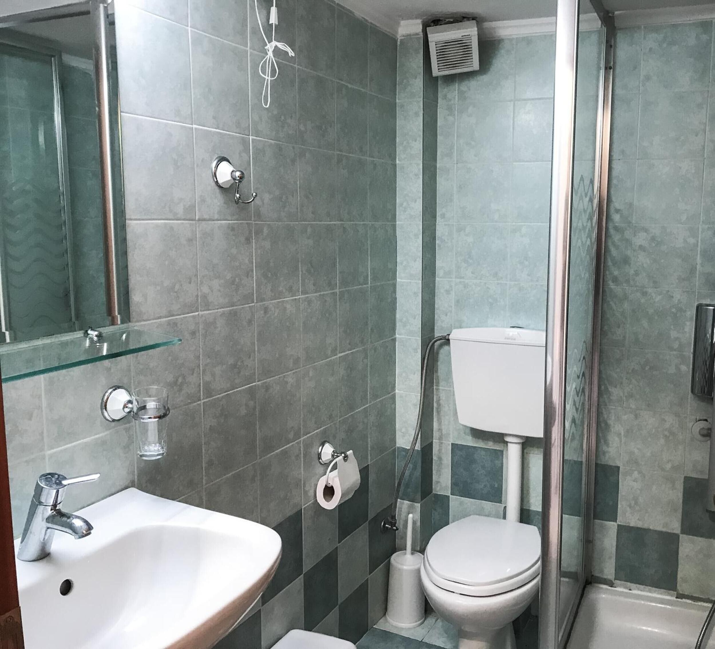 A bathroom with a sink, toilet, and shower.
