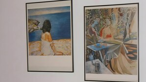 Twee kunstwerken in lijsten aan een muur.