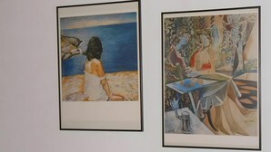 Zwei gerahmte Kunstwerke an einer Wand.