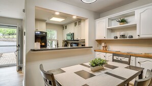 A modern kitchen with white cabinets, a built-in oven, and a dining area with a table and chairs. - Swim Dock Access! Moneta Escape, 5 Mi to Boat Ramp (Moneta)