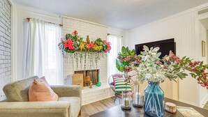 Ein Wohnzimmer mit Kamin, einer Couch, einem Couchtisch und Zierpflanzen.
