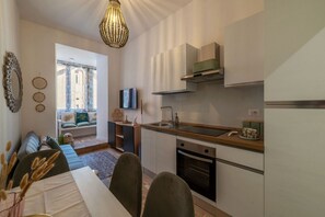 Eine moderne Küche mit eingebautem Ofen, einer Spüle und einem Essbereich mit Tisch und Stühlen.