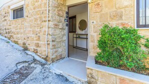 Un edificio de piedra con una puerta que da a una habitación con espejo y estante.