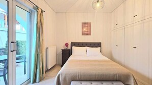 Une chambre à coucher avec un lit, une table de chevet, une lampe et une vue sur l’extérieur.