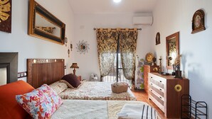 A bedroom with two beds, a dresser, a mirror, and a window with curtains.
