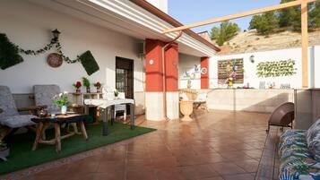 Un patio con una mesa, sillas y un sofá.