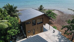 Un bâtiment moderne doté d’un toit plat, de grandes fenêtres et d’une terrasse en béton.