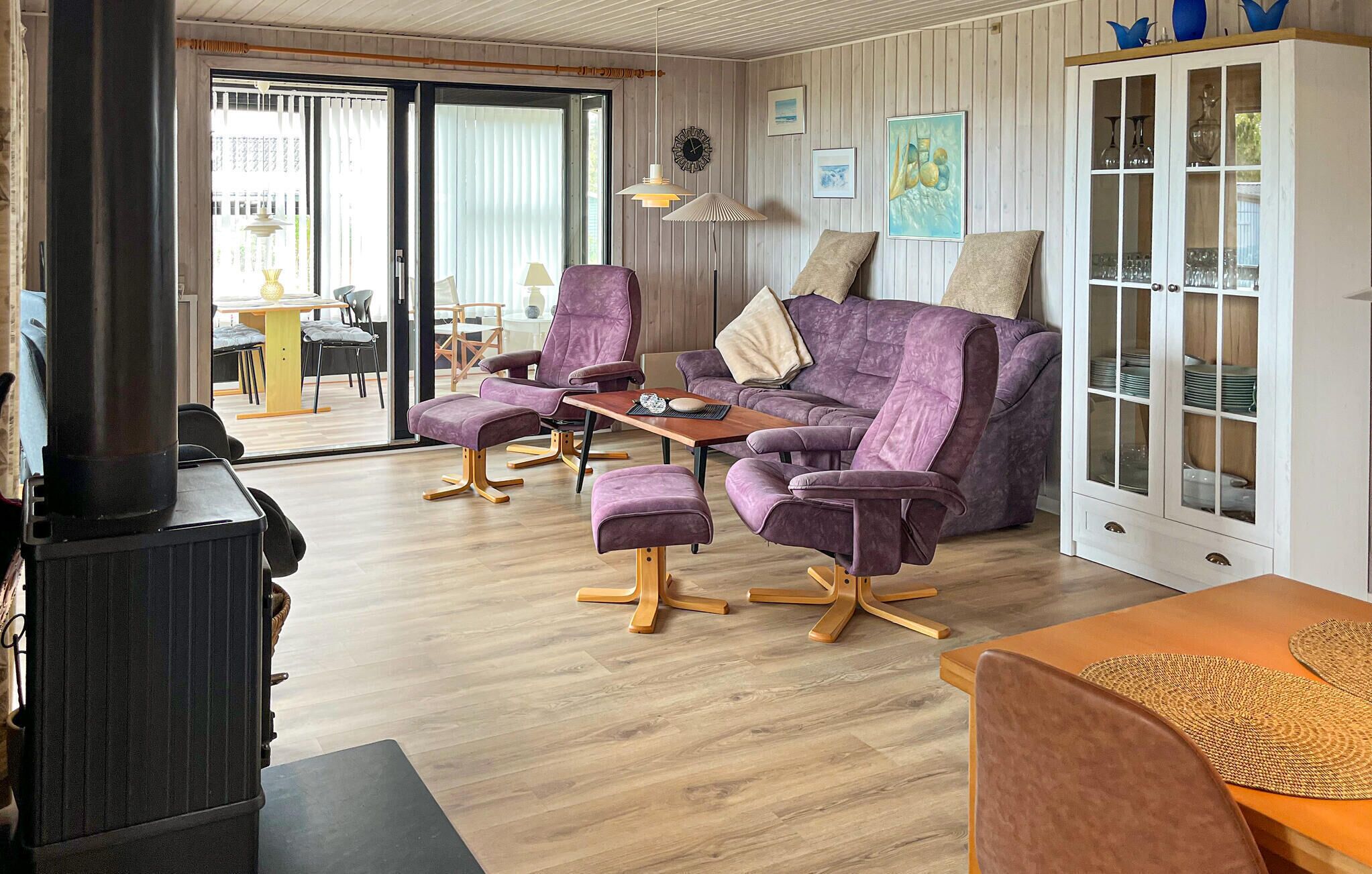 Un salon moderne comprenant un canapé, des fauteuils, une table, un meuble et une cheminée.