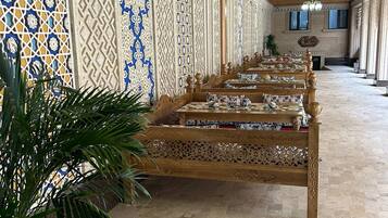 A long corridor with ornate wooden benches and patterned walls.