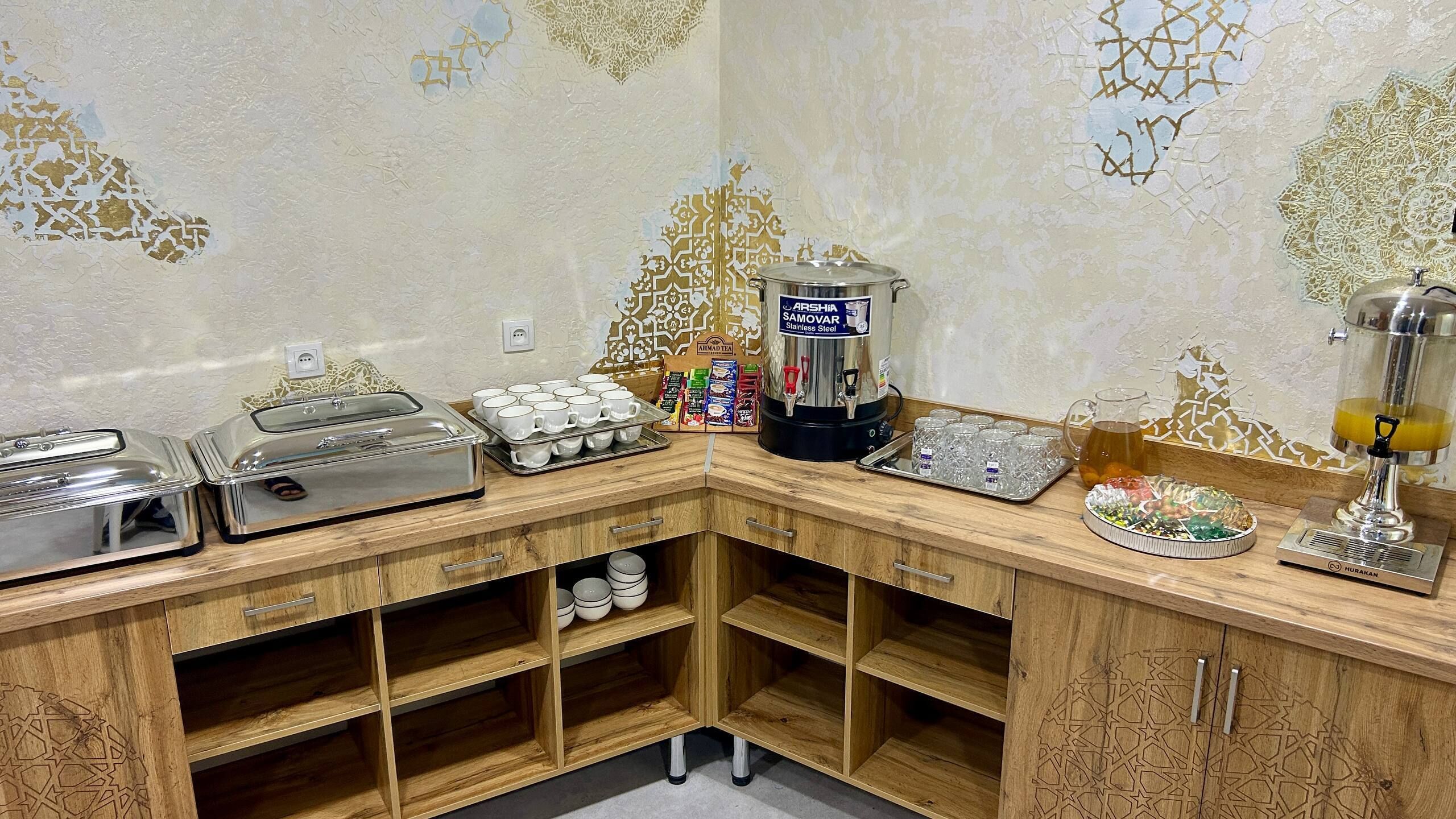 Un buffet d’angle avec un espace dédié au café, un autre au thé et une présentation de fruits.