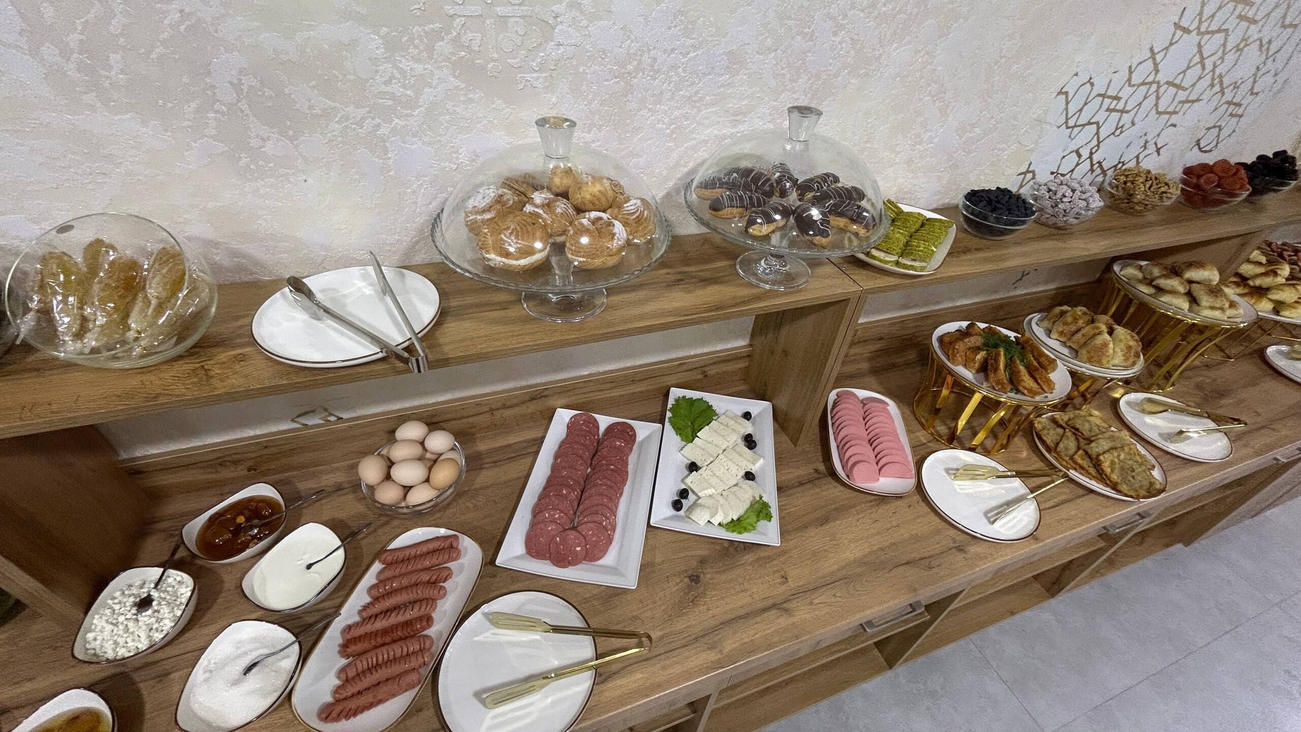 A buffet with various food items, including pastries, meats, and cheeses.