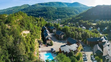 Un complexe hôtelier comprenant plusieurs bâtiments, une piscine et un paysage montagneux en toile de fond.