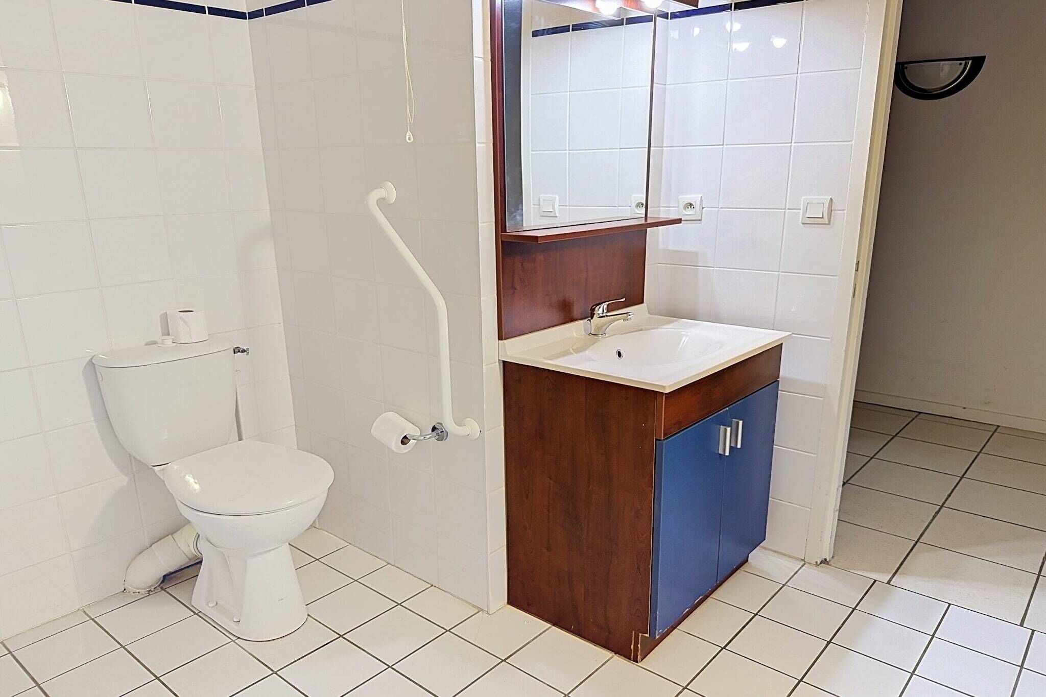 Un bagno con il water, un lavandino e uno specchio.