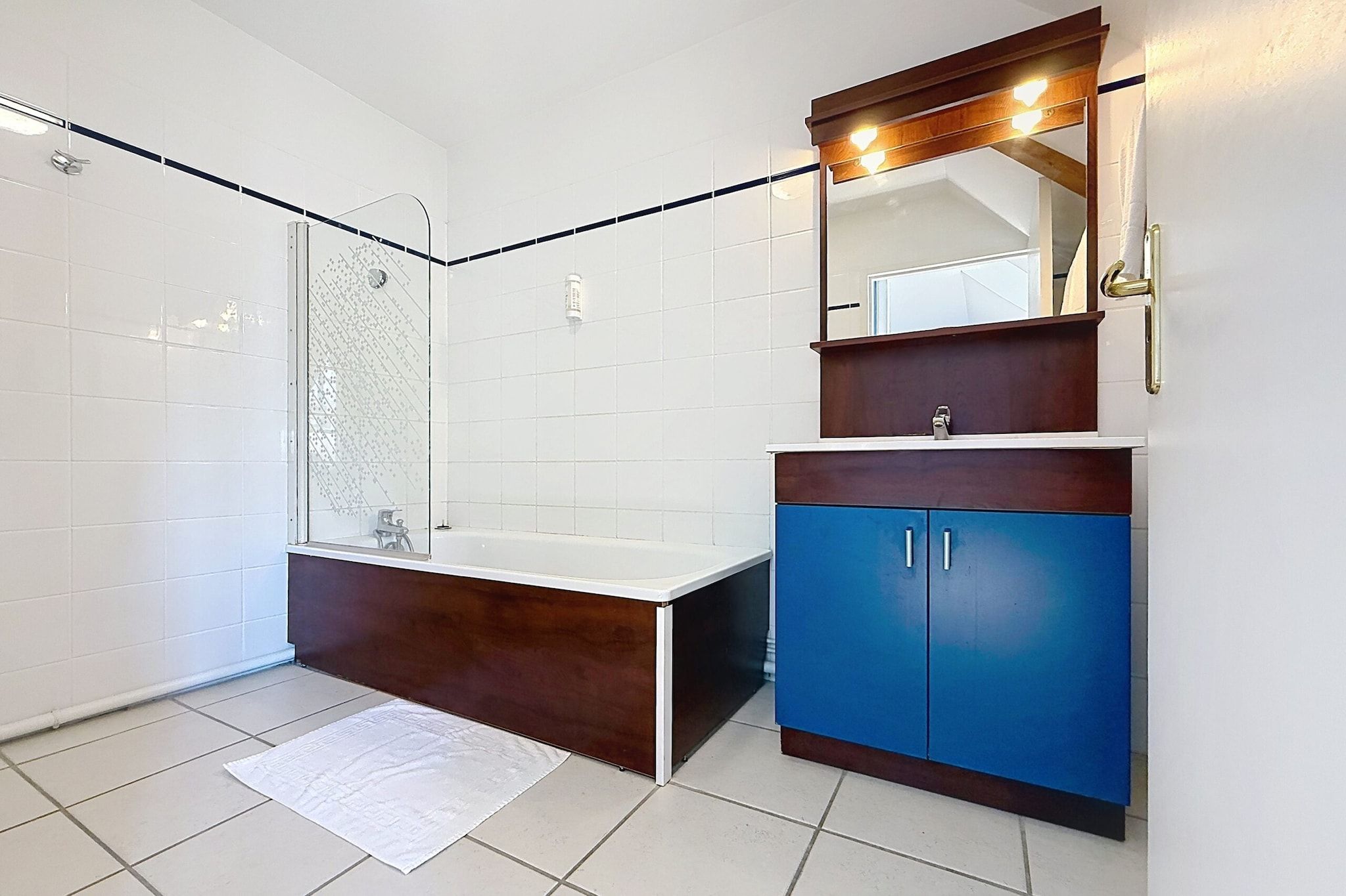 A bathroom with a shower, a bathtub, and a vanity with cabinets.
