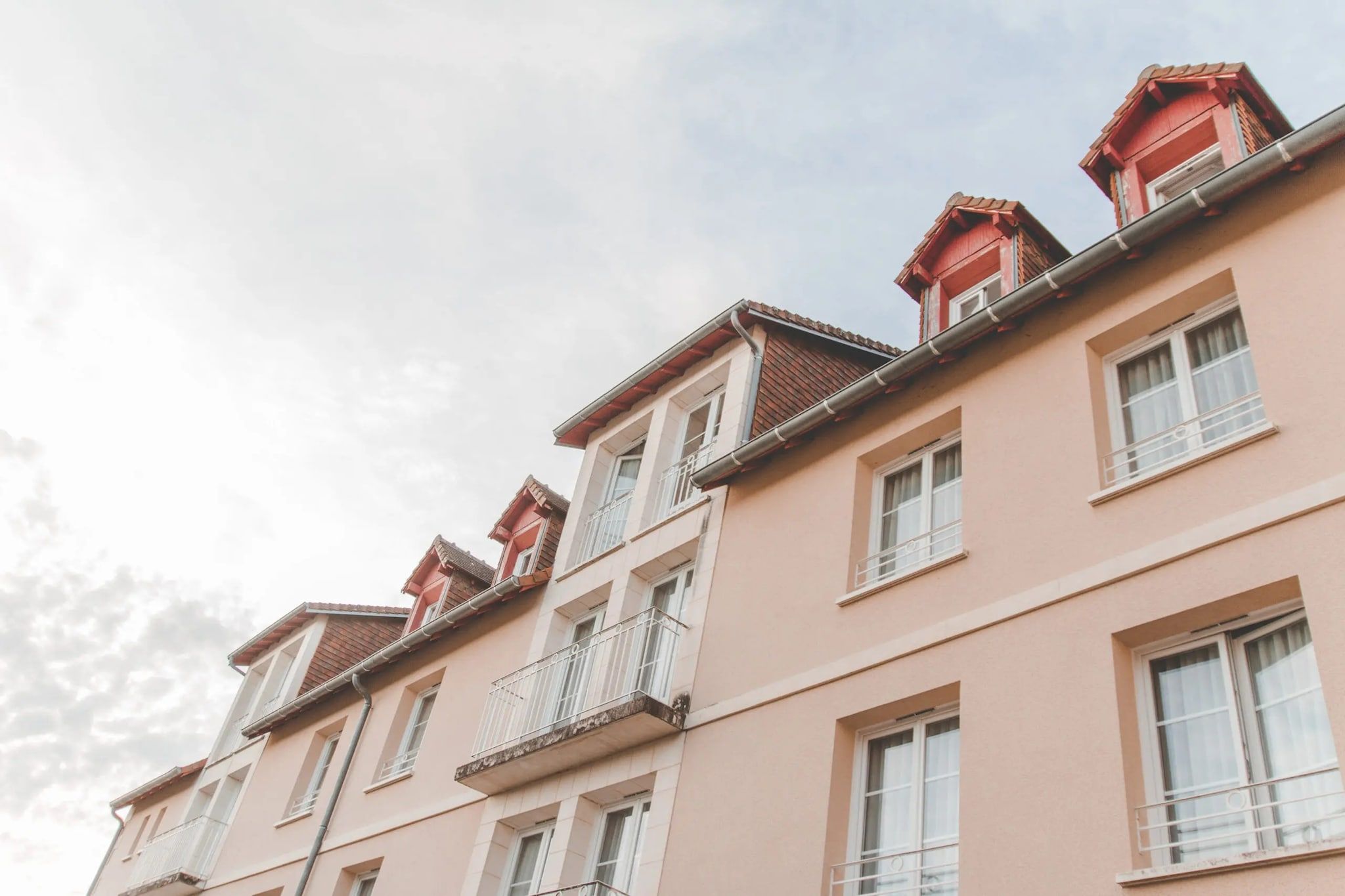 Un immeuble à plusieurs étages doté de balcons et de fenêtres.