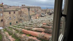 A view of terracotta-tiled rooftops and stone buildings, with a cloudy sky. - Prestigious penthouse in Maffei Palace, in the very center of Volterra (Volterra)