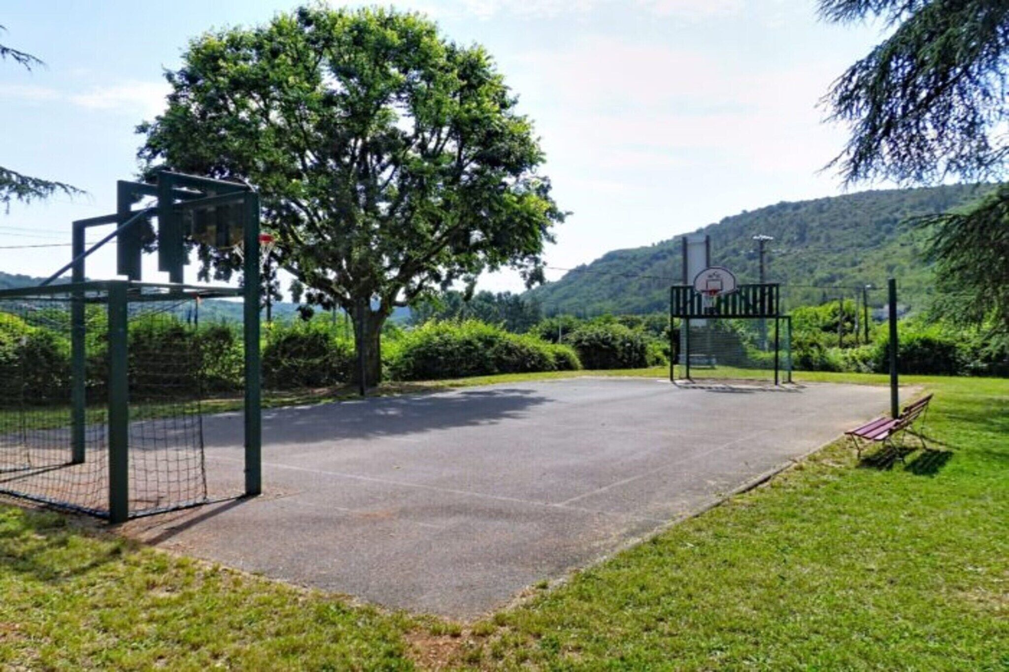 A basketball court with a hoop and a fence.