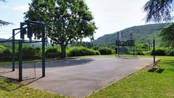 A basketball court with a hoop and a fence.