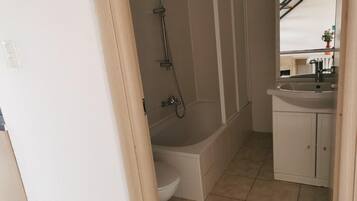 A bathroom with a bathtub, toilet, and sink.