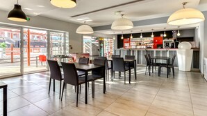 A restaurant with tables and chairs, a bar area, and large windows. - Escape with Pool, Gym & Balcony (Argeles-sur-mer)