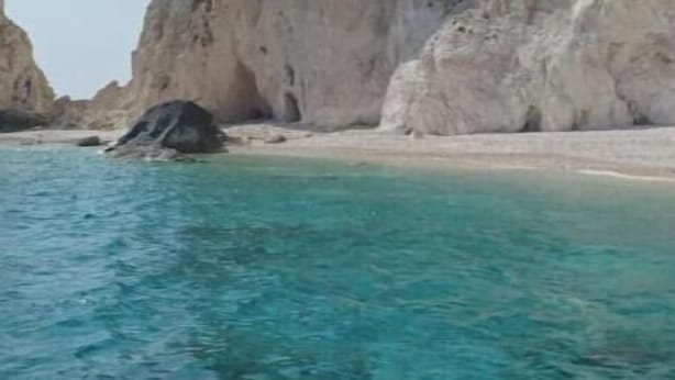 A coastal landscape with clear turquoise water, rocky cliffs, and a sandy beach. - Casa al Porto (Zakinthos)