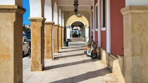 A corridor with arches, a scooter, and a street visible in the background. - Casa al Porto (Zakinthos)
