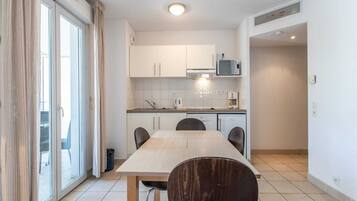 A modern kitchen with a dining table, chairs, and a microwave.